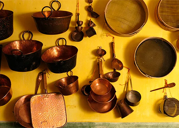 The family’s traditional copper pots and sieves on the kitchen wall